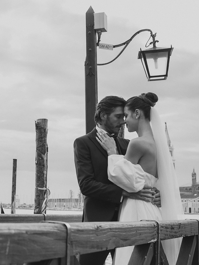 Venice Destination Wedding: a bride and a groom kissing on a dock