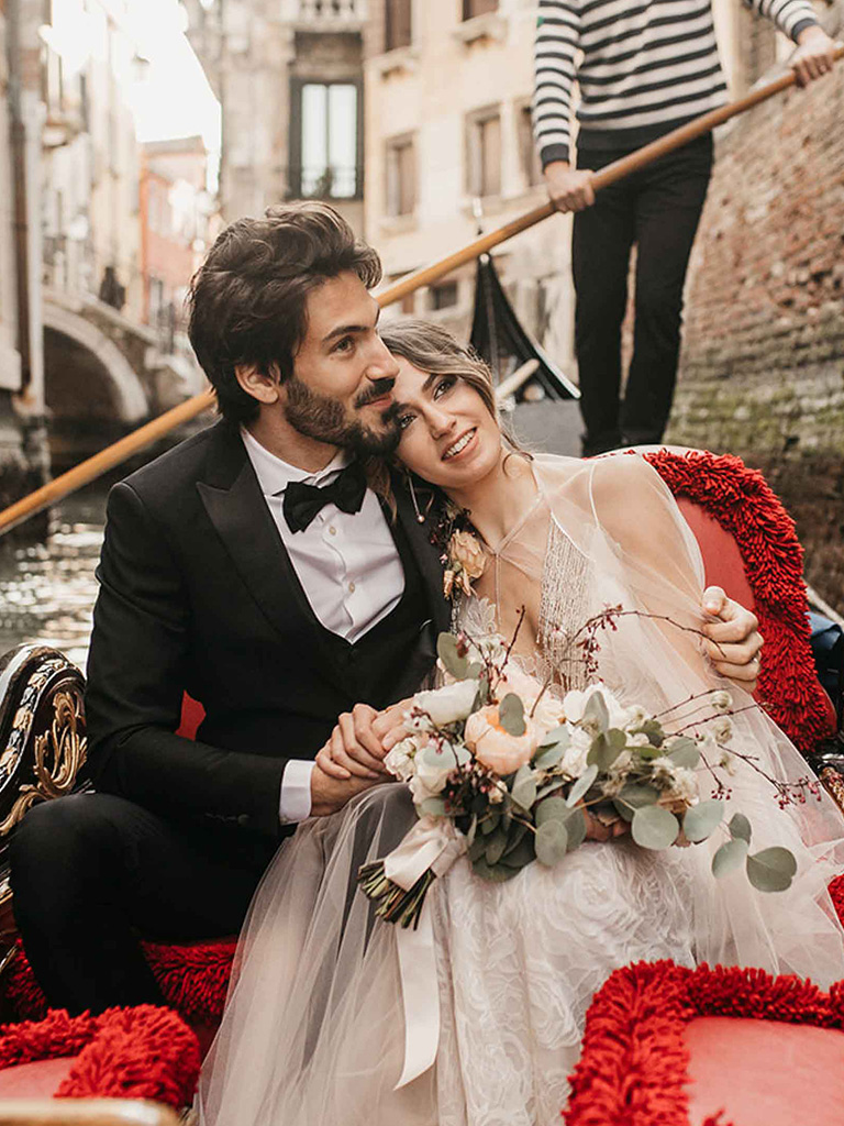 A bride and a groom on a gondola in Venice