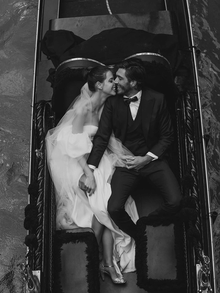 Venice Destination Wedding: a bride and a groom kissing on a gondola